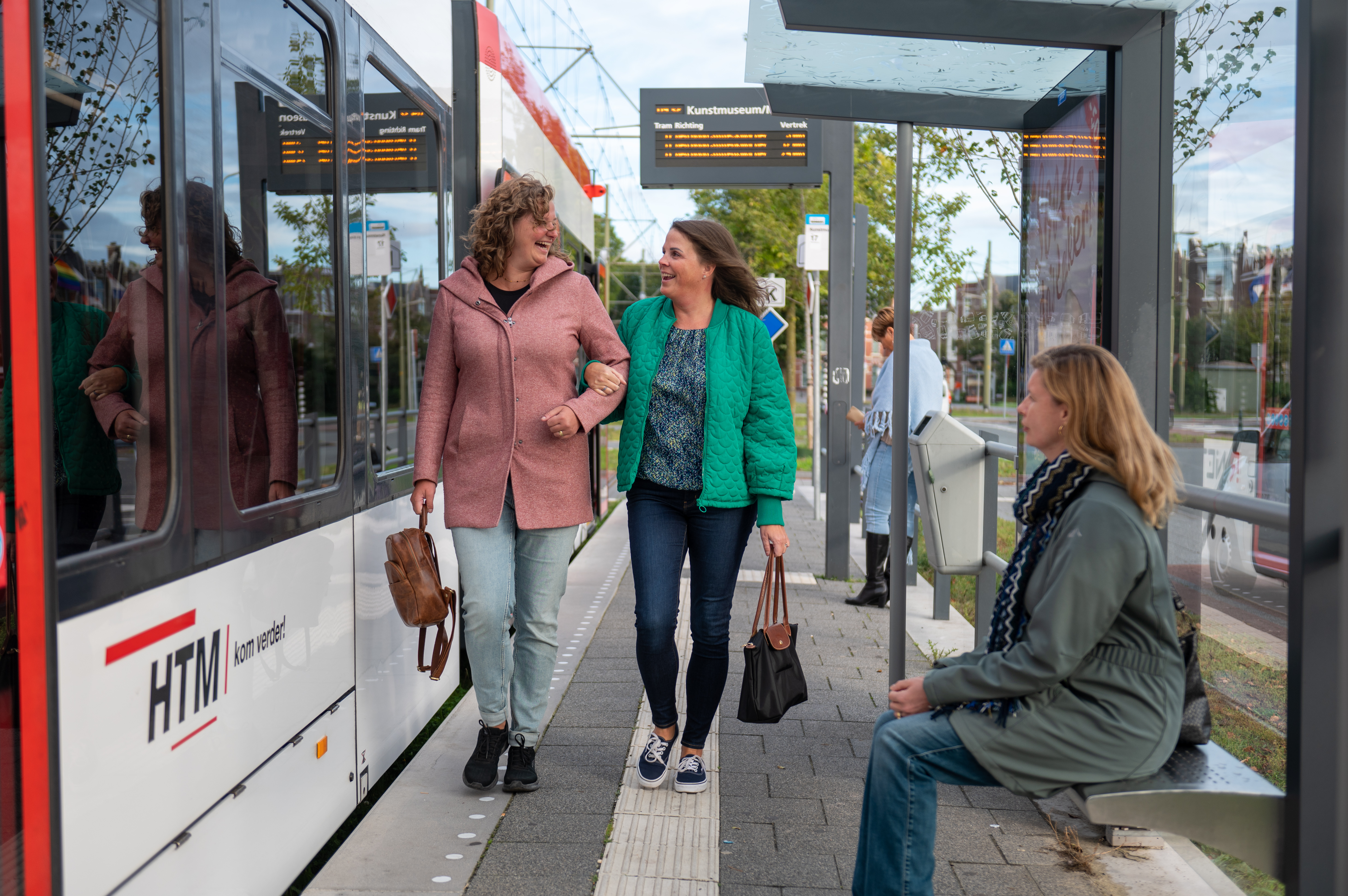 Reizigers lopen op halte naast HTM tram