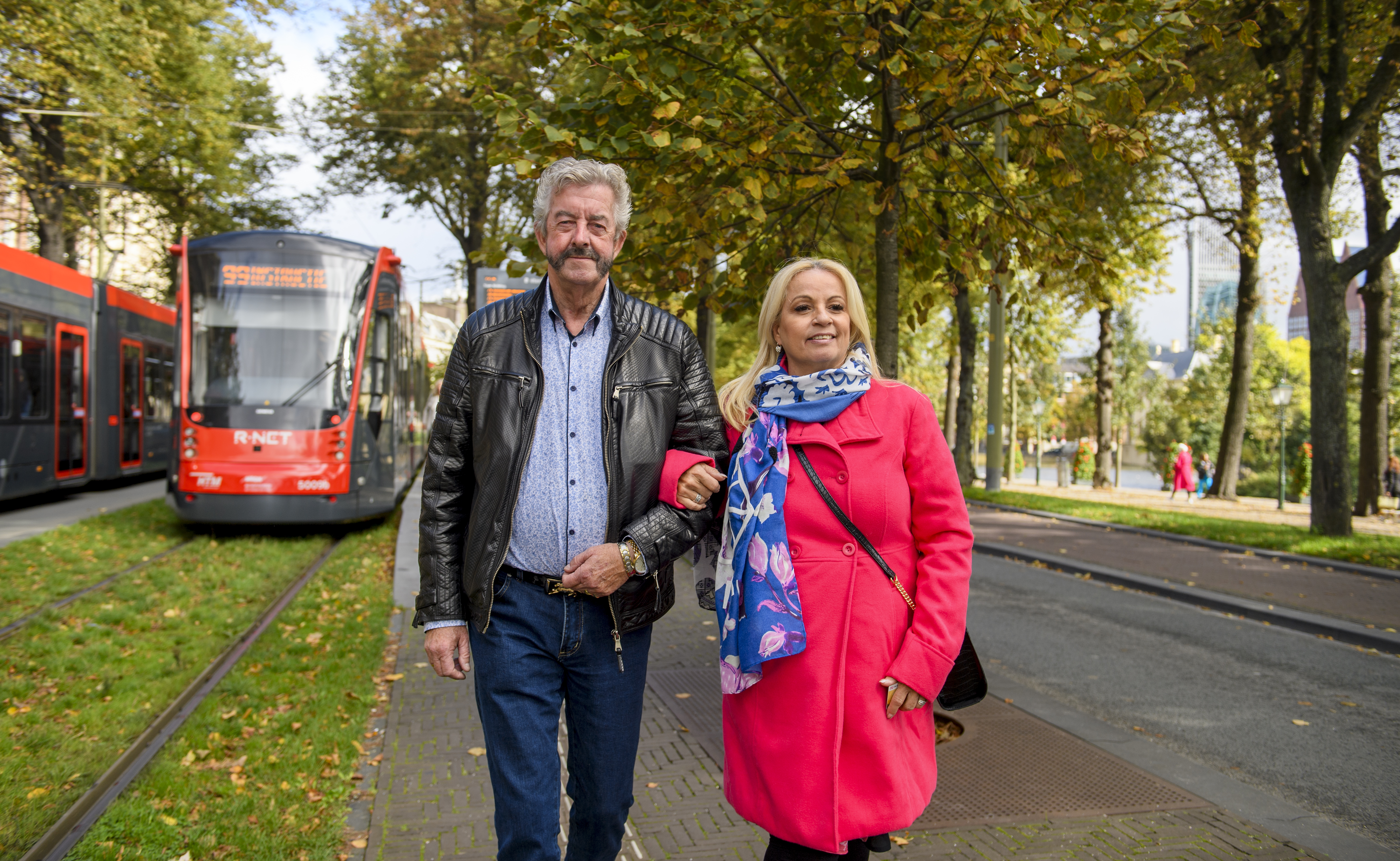Reizigers Avenio lopen naast HTM tram