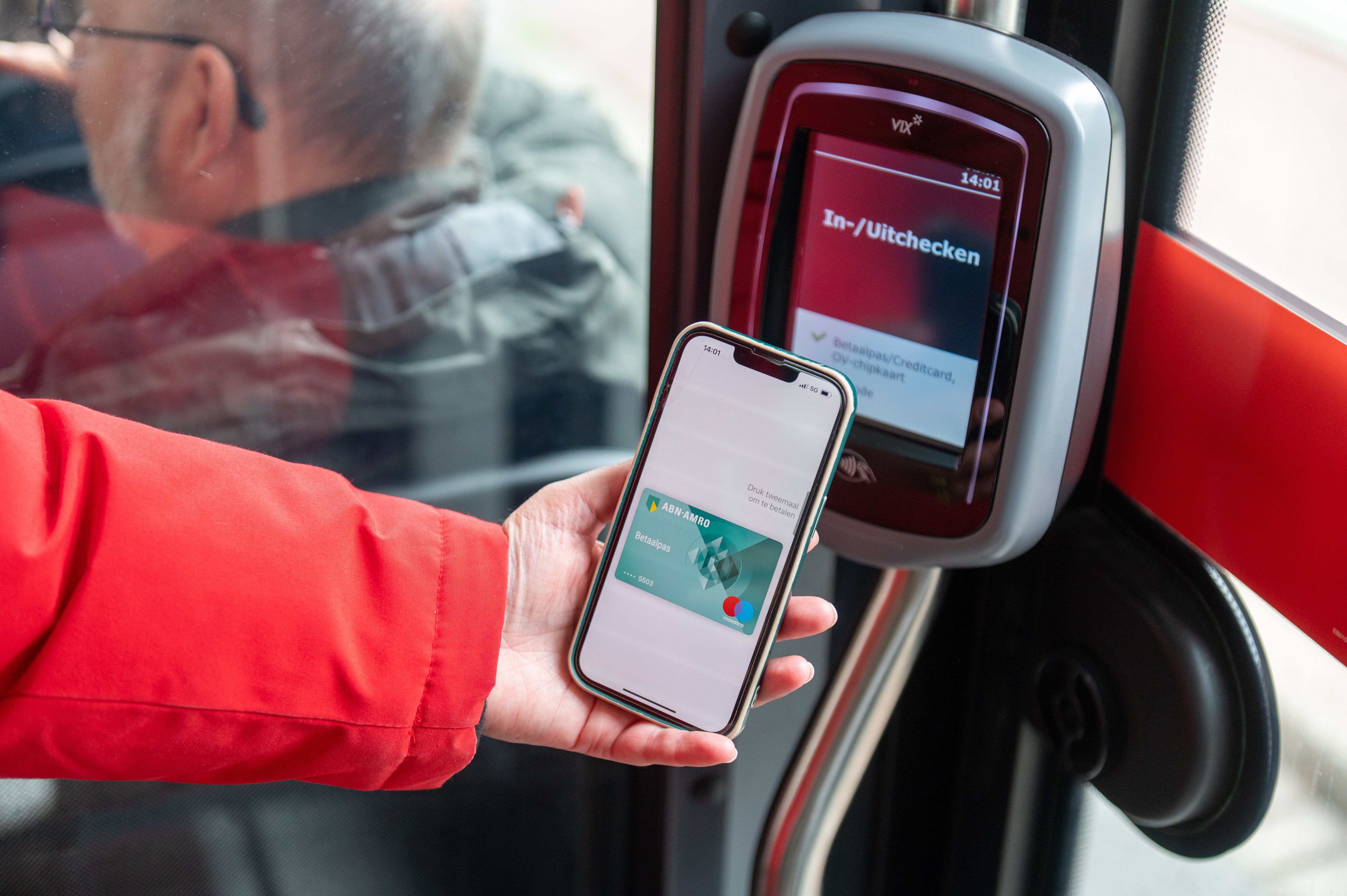 Reiziger checkt in met OV-pay in HTM tram