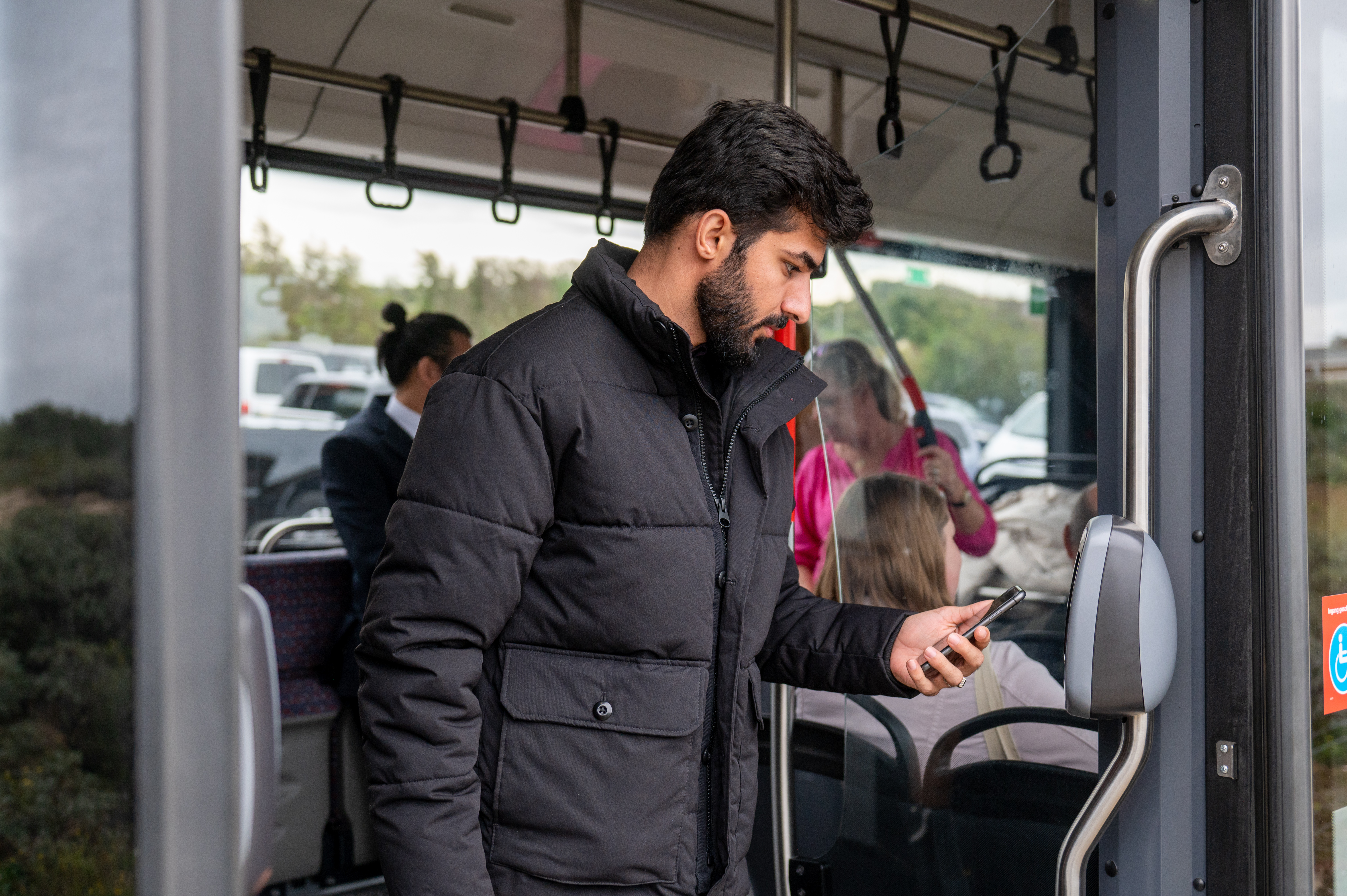Reiziger checkt uit met OV-pay in HTM tram