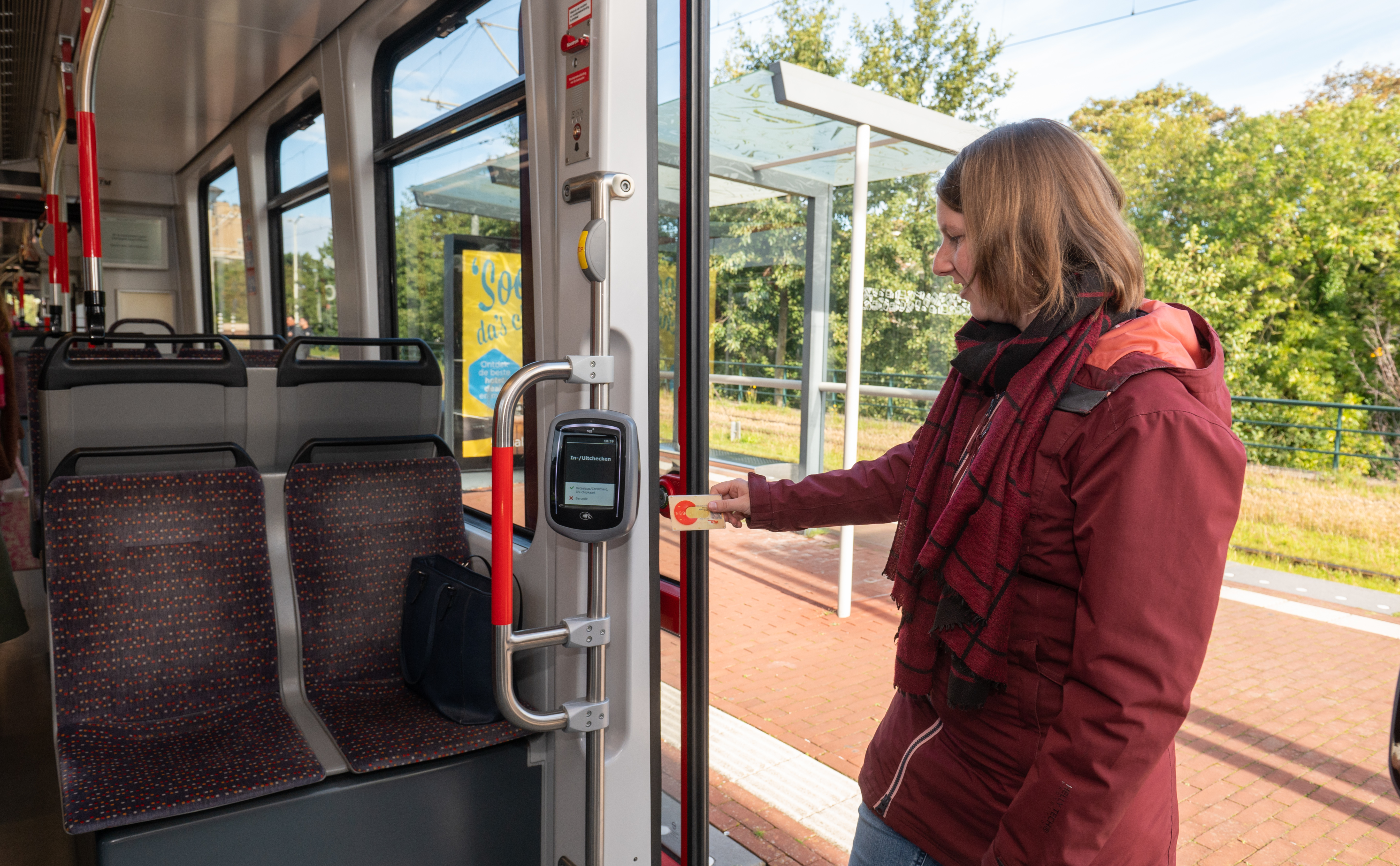 Reiziger checkt in met OV-chipkaart in HTM tram