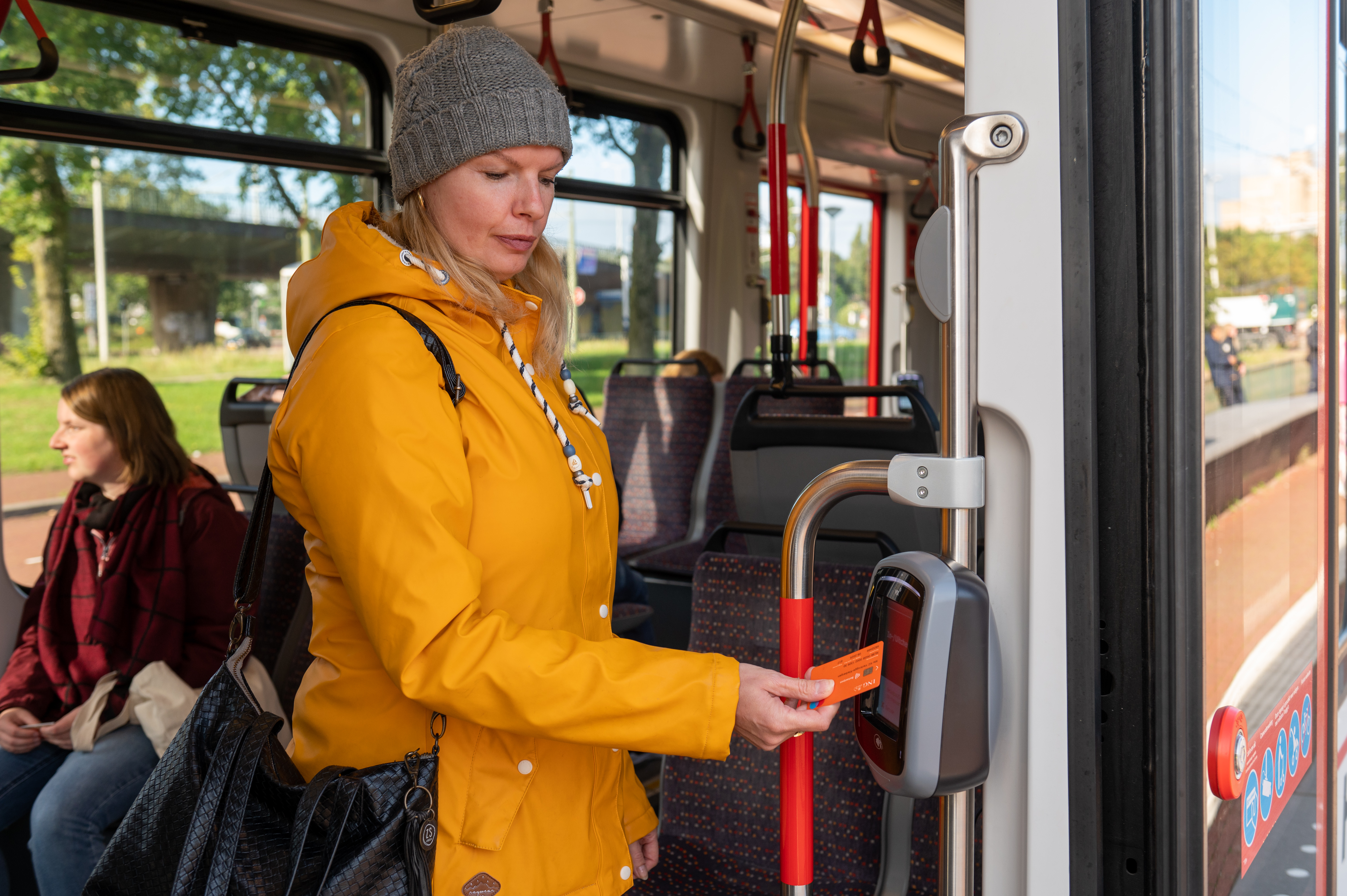 Reiziger checkt uit met OV-pay in HTM tram