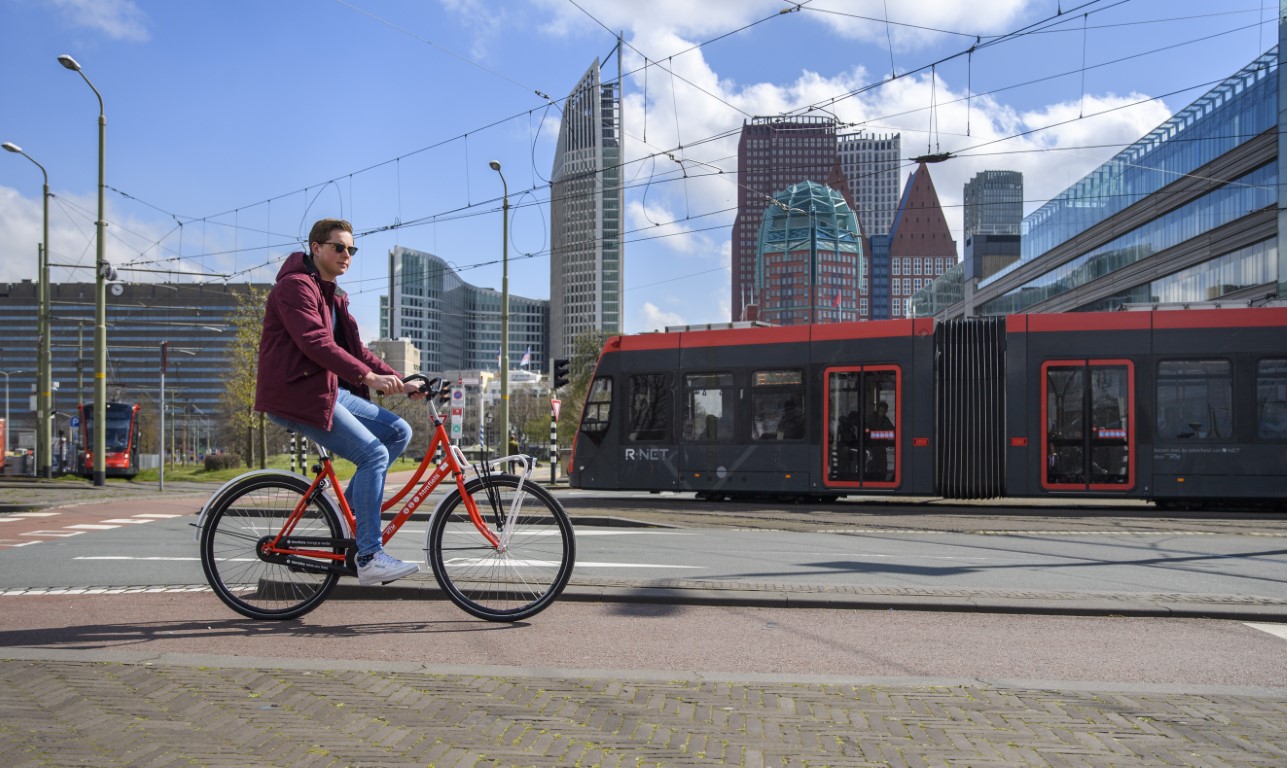 Reiziger rijdt op HTM fiets